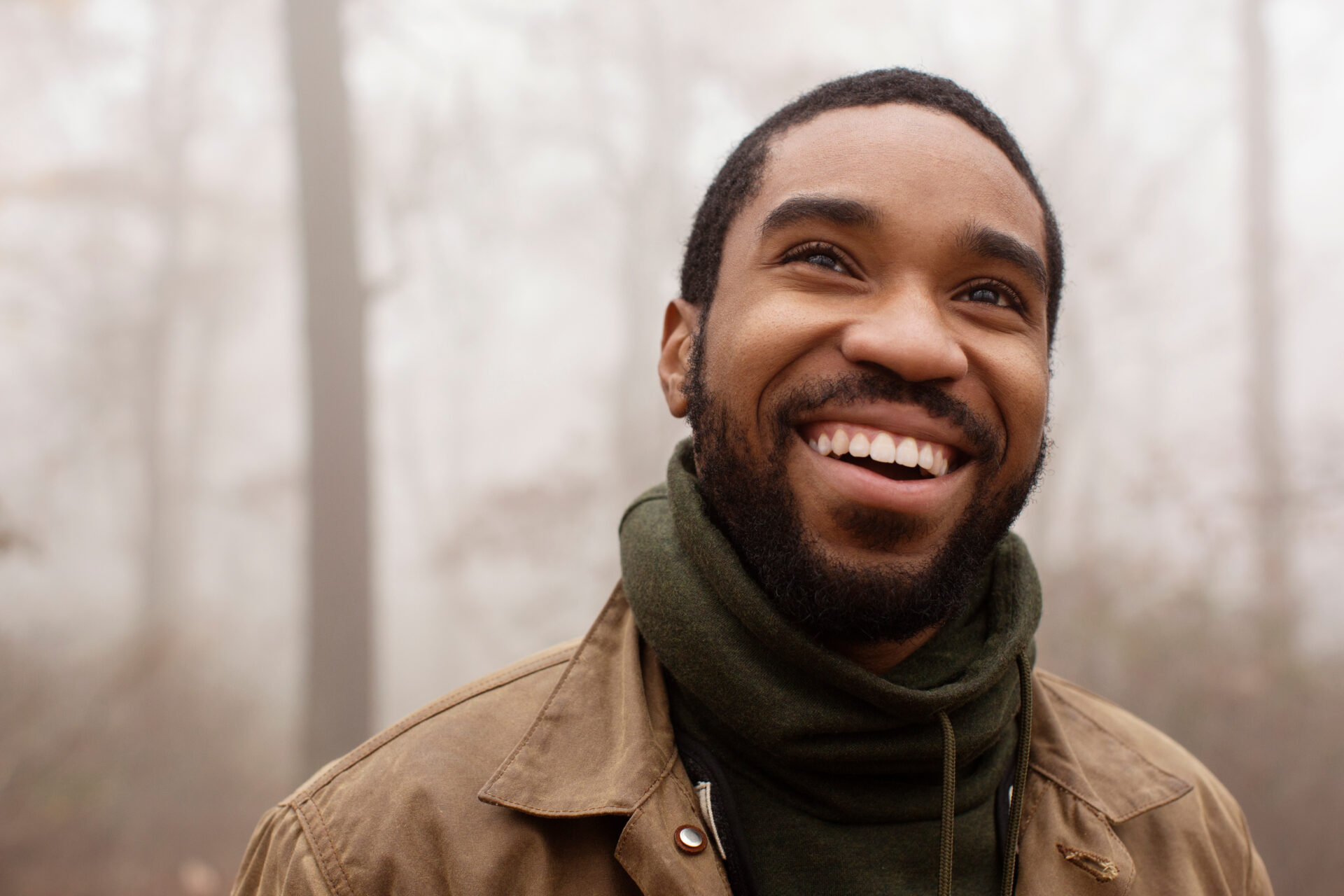 Smiling man looking away in forest